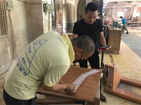 設(shè)計(jì)師看著產(chǎn)品工程師做首件家具前，按著1:1做出來(lái)的模板，核對(duì)每一處比例。